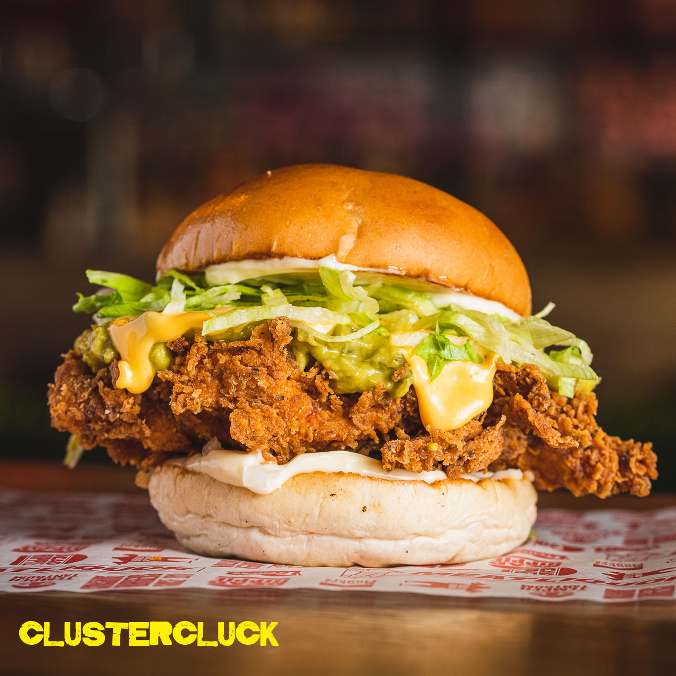 CLUSTERCLUCK | DREDGED & FRIED CHICKEN BREAST, GREEN CHILLI BUTTER, DICED JALAPENO, MAYO, DICED WHITE ONION, CHEESE SAUCE, LETTUCE Image
